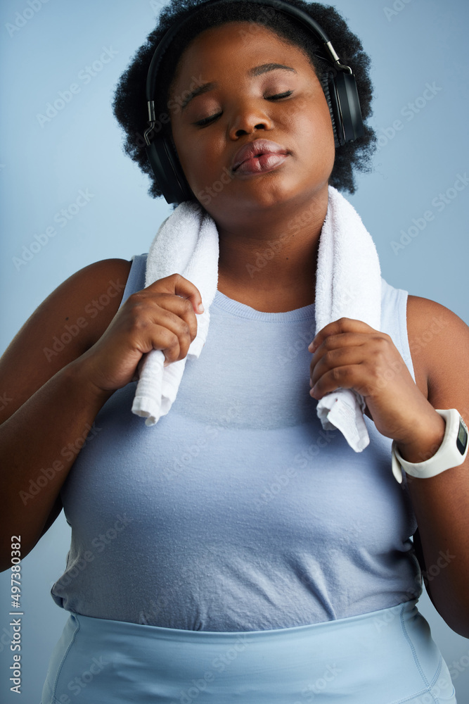 At peace with her personal progress. Studio shot of an athletic young woman posing against a blue ba