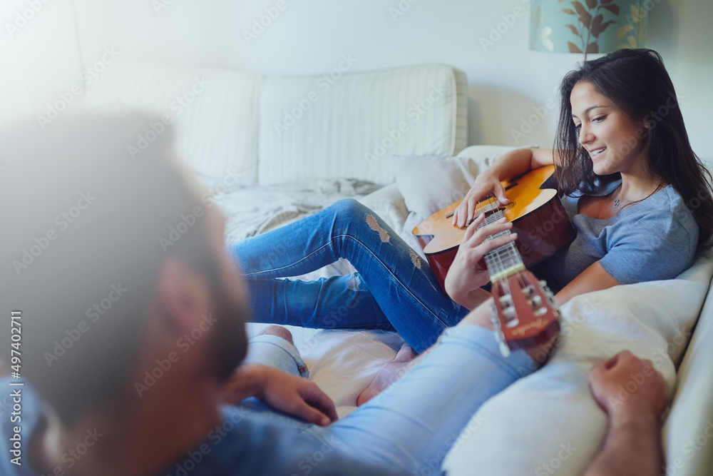 我为你写了这首歌。一个年轻女人坐在一起为男友弹吉他的镜头