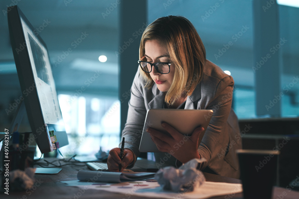 全天候为她服务。一位年轻的女商人在数字账单上工作到很晚的照片