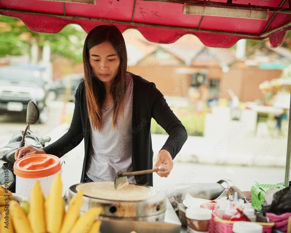 马上就要来了。泰国一名食品摊贩准备美味小吃的镜头。