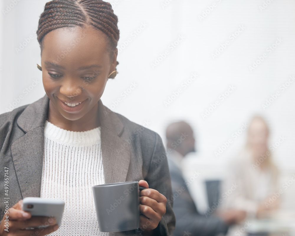 Shes always updated with whats new. Shot of a young businesswoman drinking coffee while using a cell