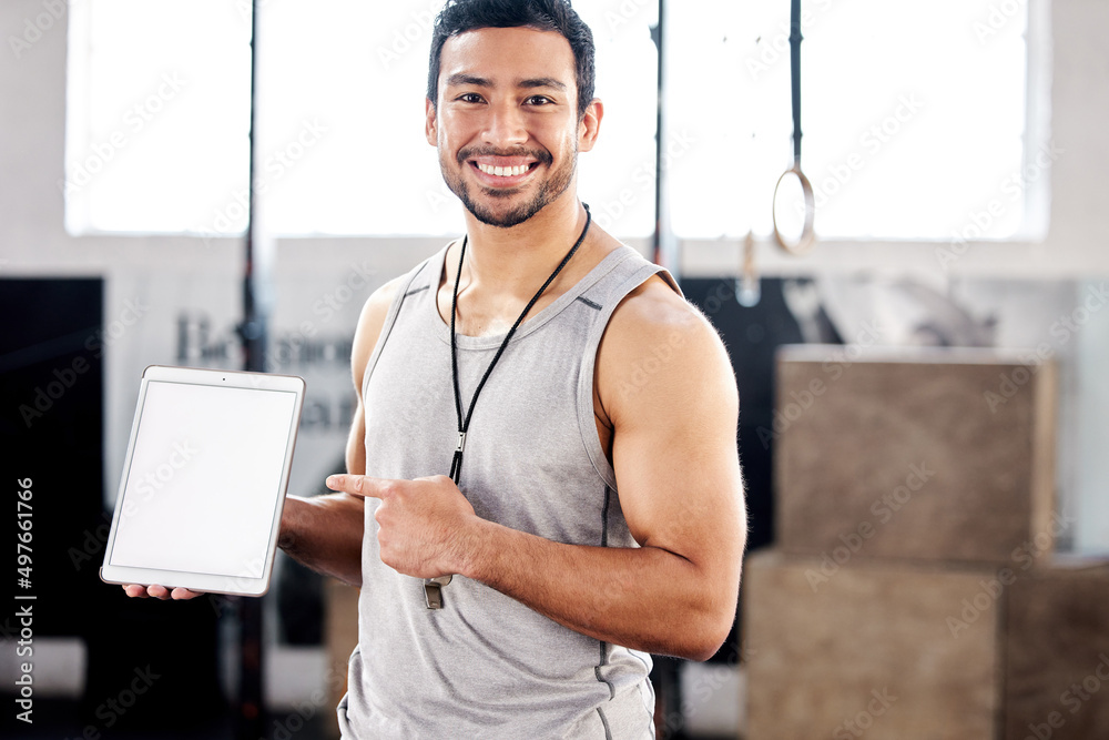 Youll want me in your corner. Shot of a handsome young man using a digital tablet at the gym.