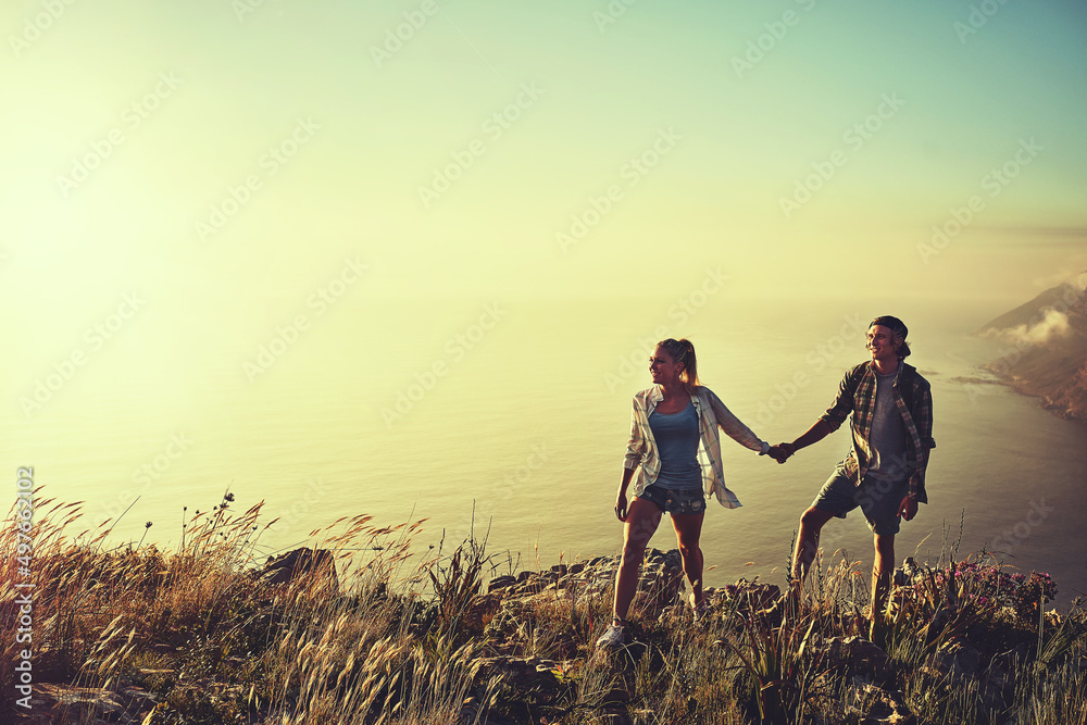 Lets explore the path less traveled. Shot of an affectionate young couple bonding while out on a hik