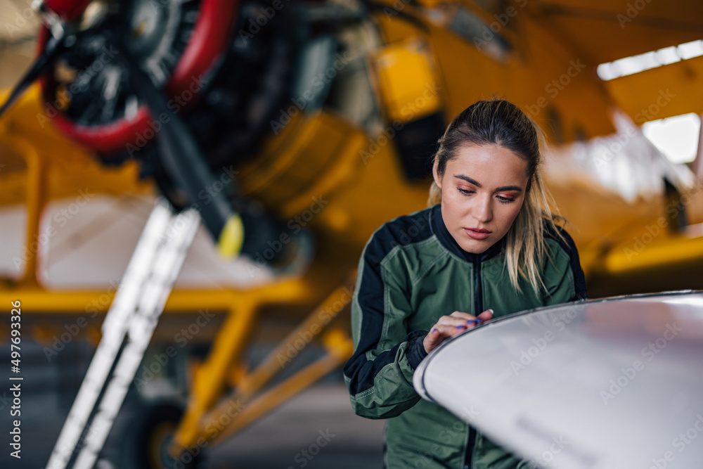 Focused girl, doing something in a plane garage.