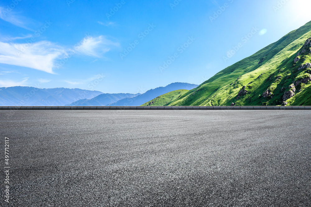 蓝天下空旷的柏油路和青山自然景观。道路和山脉背景