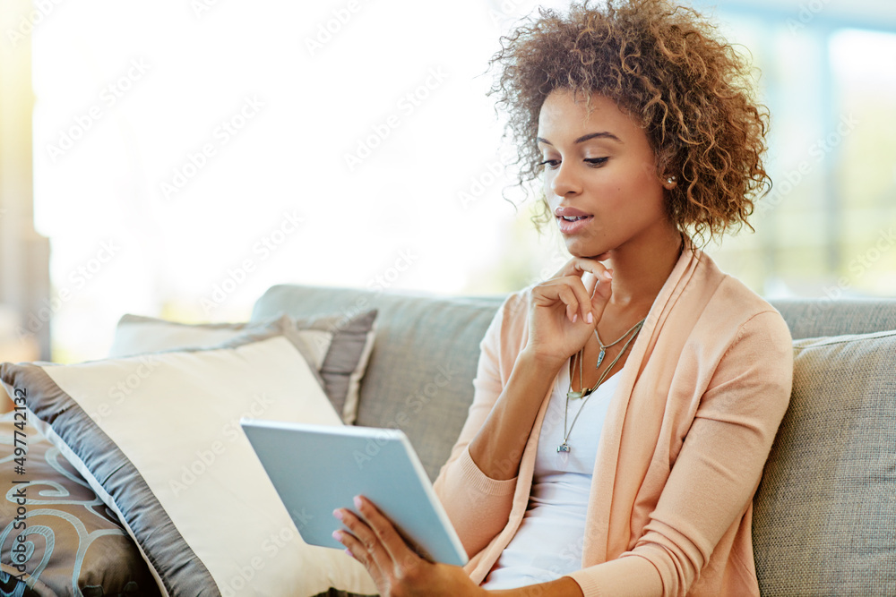 Which show should I stream. Shot of a young woman using a digital tablet at home.