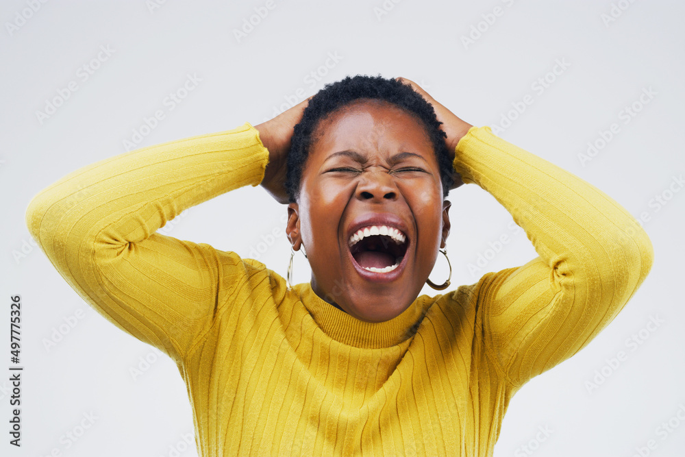 Im done with this. Studio shot of an attractive young woman looking stressed out against a grey back