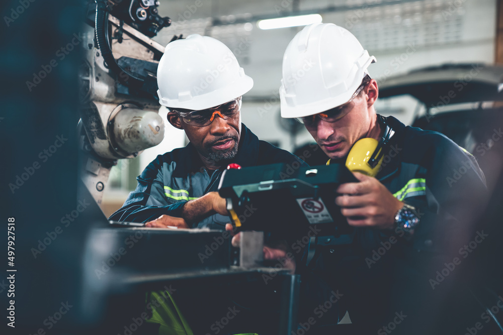 Factory workers working with adept robotic arm in a workshop . Industry robot programming software f