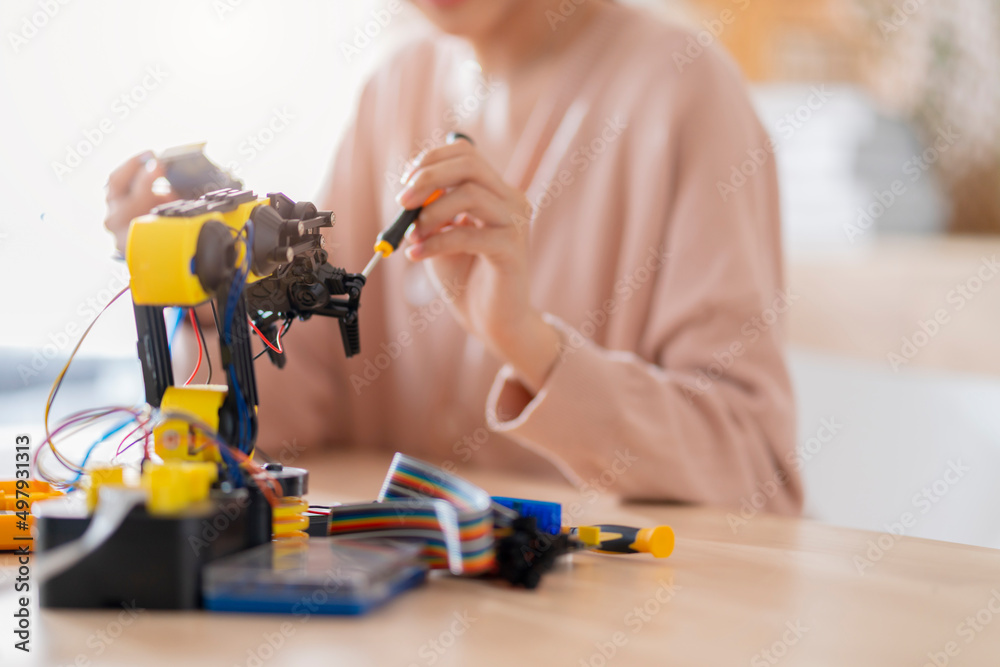 smart asian female programer learning robot arm ai coding electronic board cable in STEM, STEAM she 