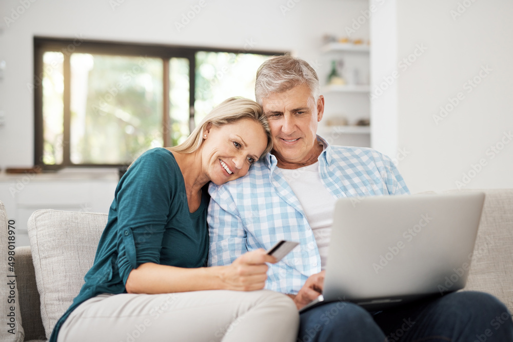 So...what are we buying today. Cropped shot of an affectionate mature couple using their laptop to d