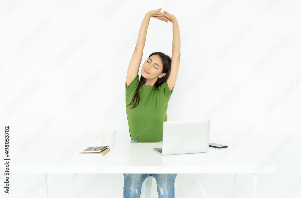 Young Asian woman freelancer in casual clothing are stretch hands with eyes closed for relaxation on