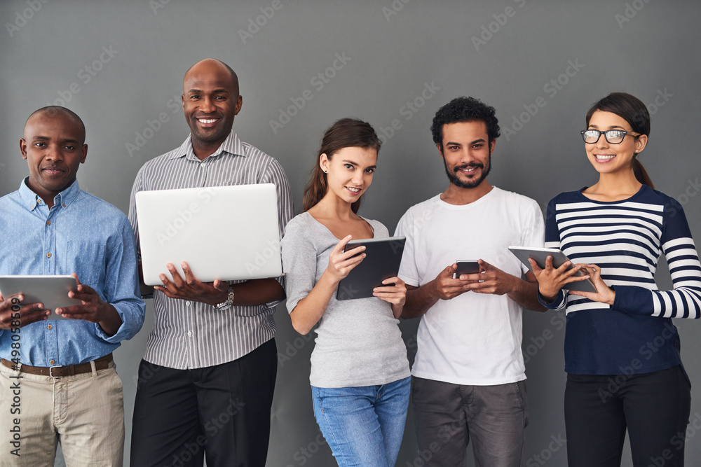 Theres a gadget for all your needs. Studio shot of businesspeople using wireless technology against 