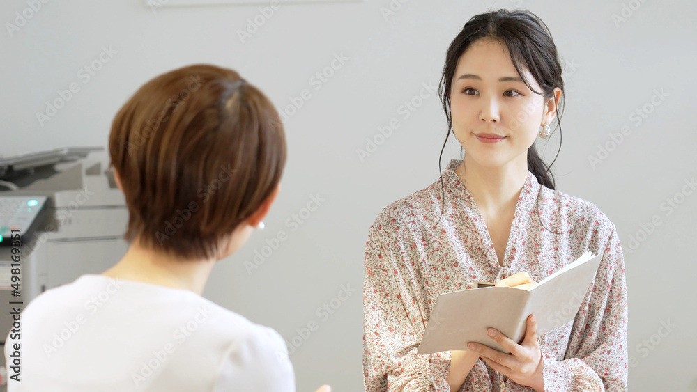 話を聞いてメモをを取る女性