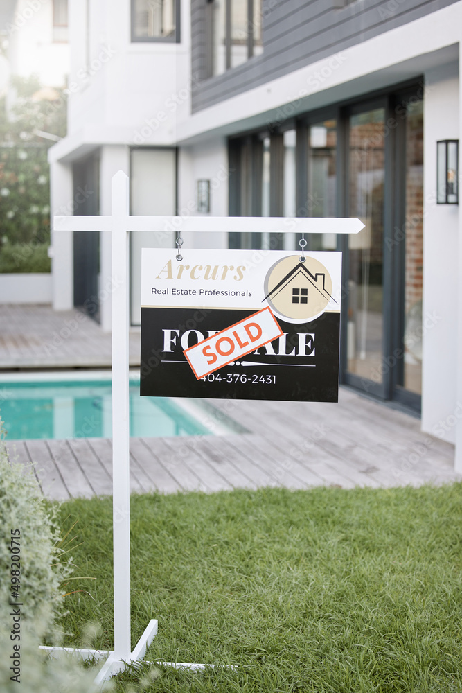 Home is the nicest word there is. Shot of for sale sign with a sold sticker outside a house.