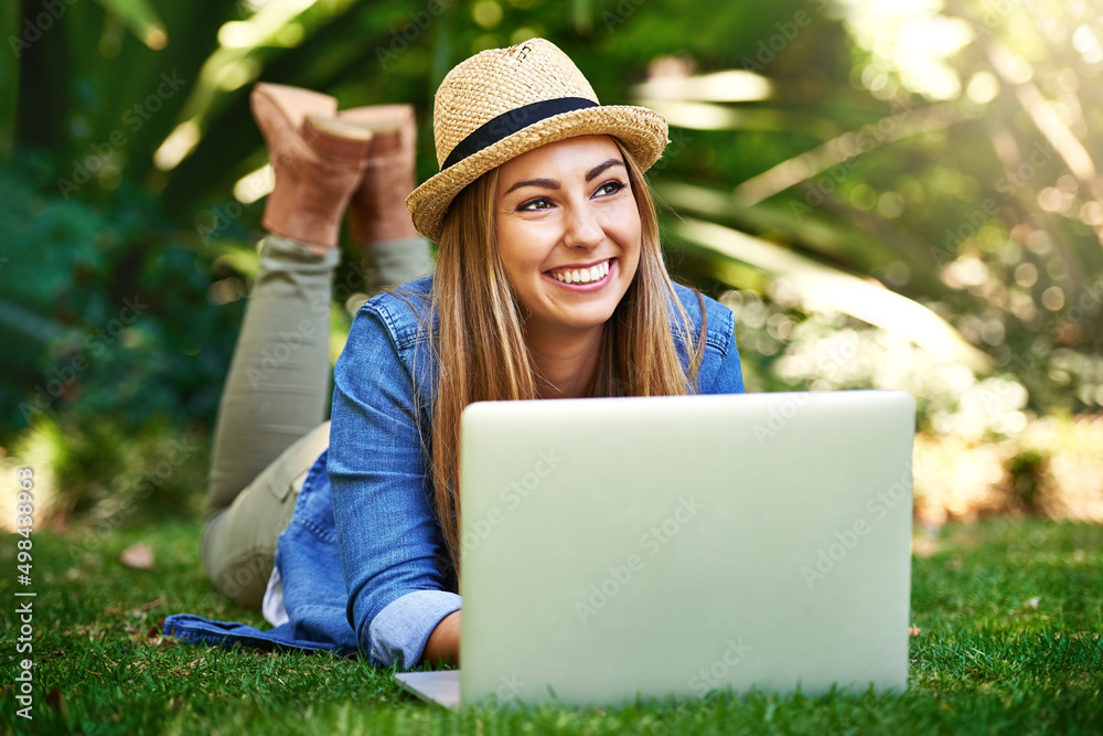 Thinking about her next article. Shot of an attractive young woman using her laptop while outside on