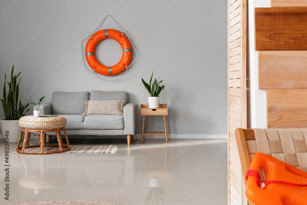 Interior of modern living room with lifebuoy, sofa and houseplants