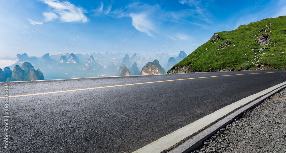 夏季蓝天下的沥青公路和山地自然景观。道路和山地背景