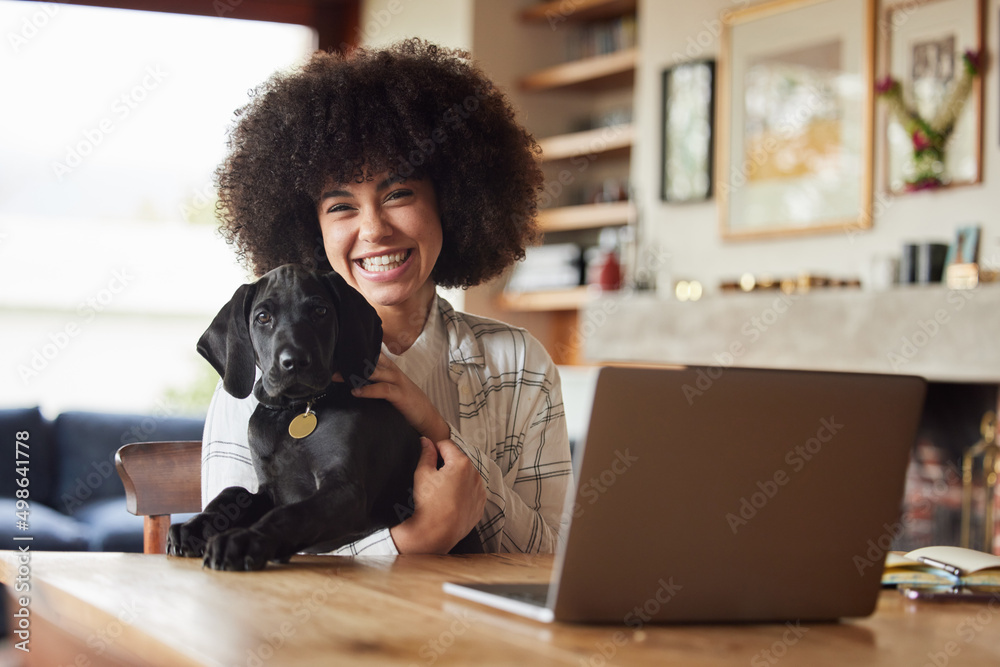 The dog is a gentleman. Shot of a young woman playing with her dog at home.