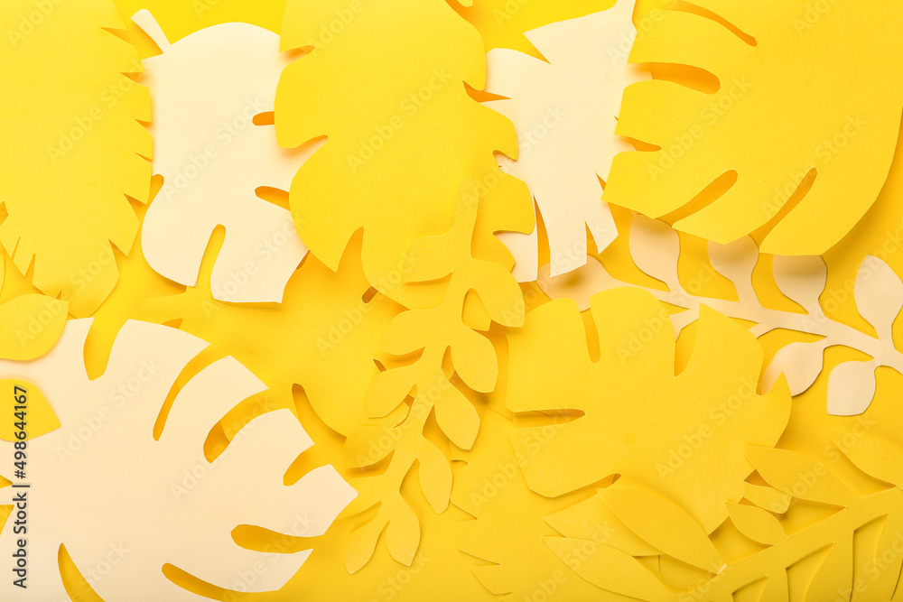 Paper tropical leaves on yellow background