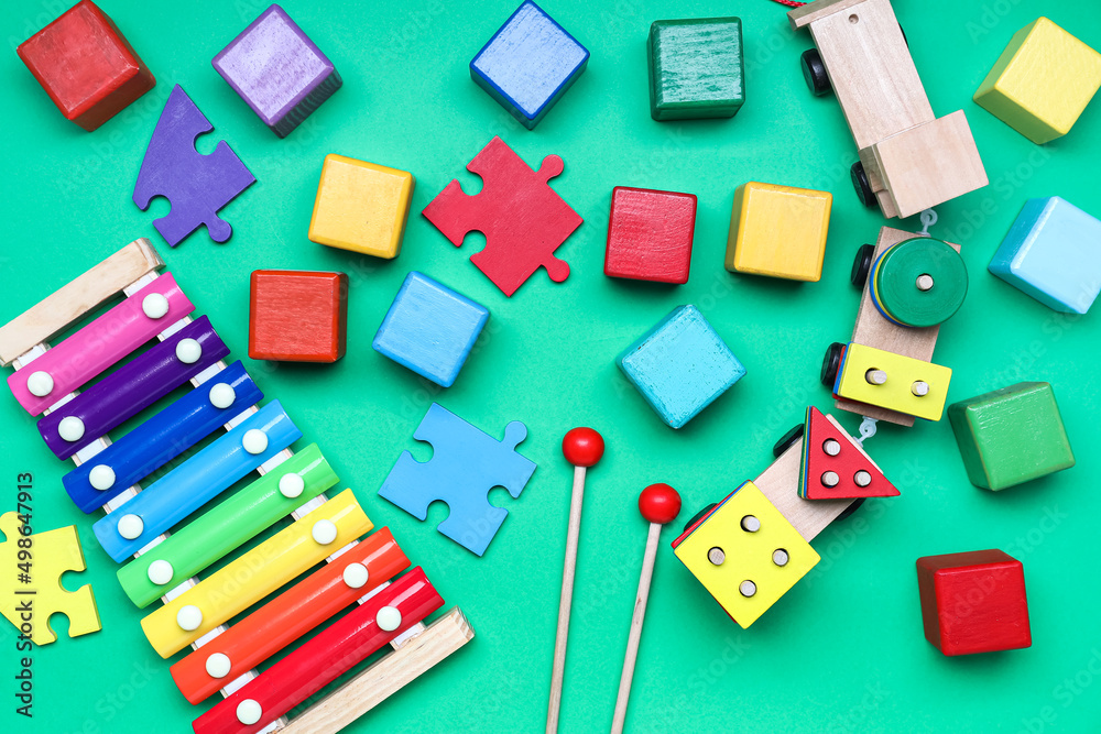 Wooden cubes with puzzle pieces and xylophone on color background