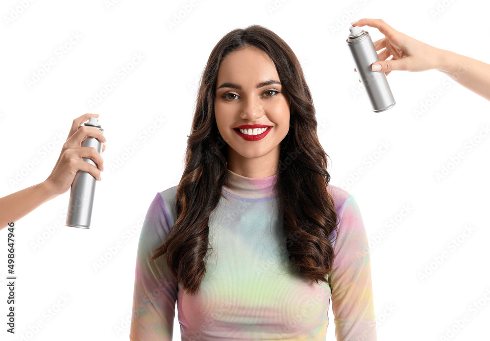 Beautiful young woman and hands with hair spray on white background