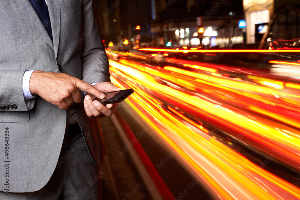 This app will get me a cab in no time. A cropped shot of a businessman texting while standing beside