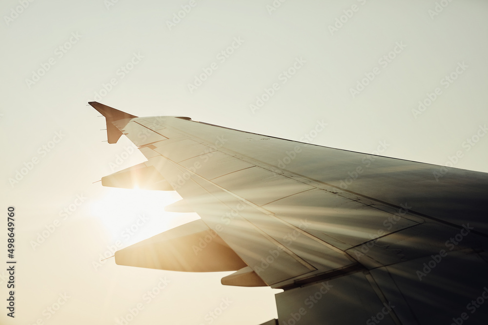 Lets fly away. Cropped shot of an airplanes wing in mid flight.