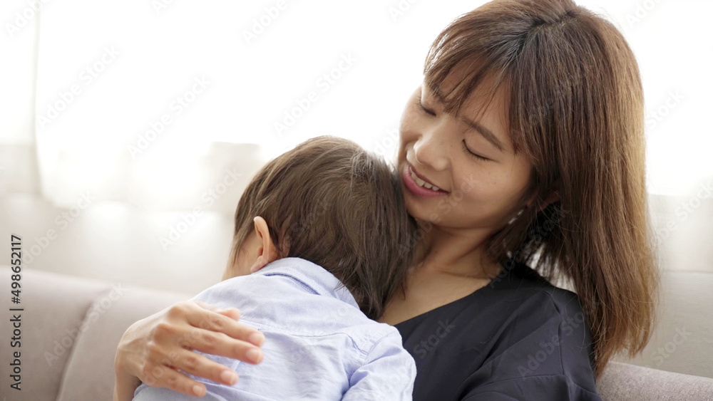 昼寝する男の子を見守るお母さん