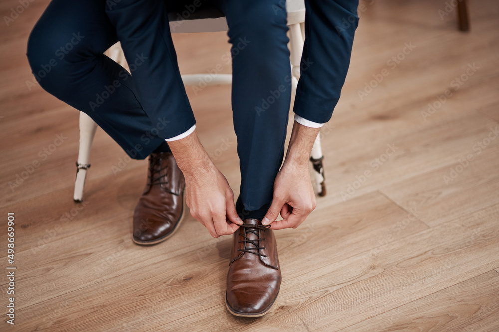 All set to jump the broom. Cropped shot of an unrecognizable bridegroom tying his shoelaces in prepa