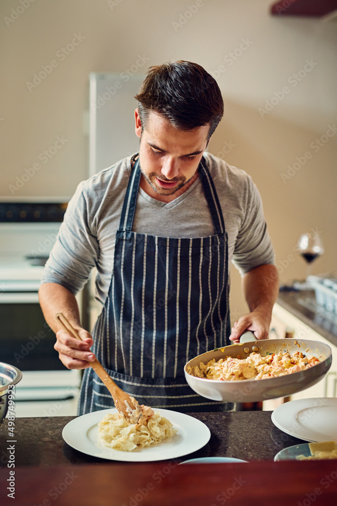 生活是一个厨房，穿上围裙做饭。一个年轻人在厨房做饭的镜头。