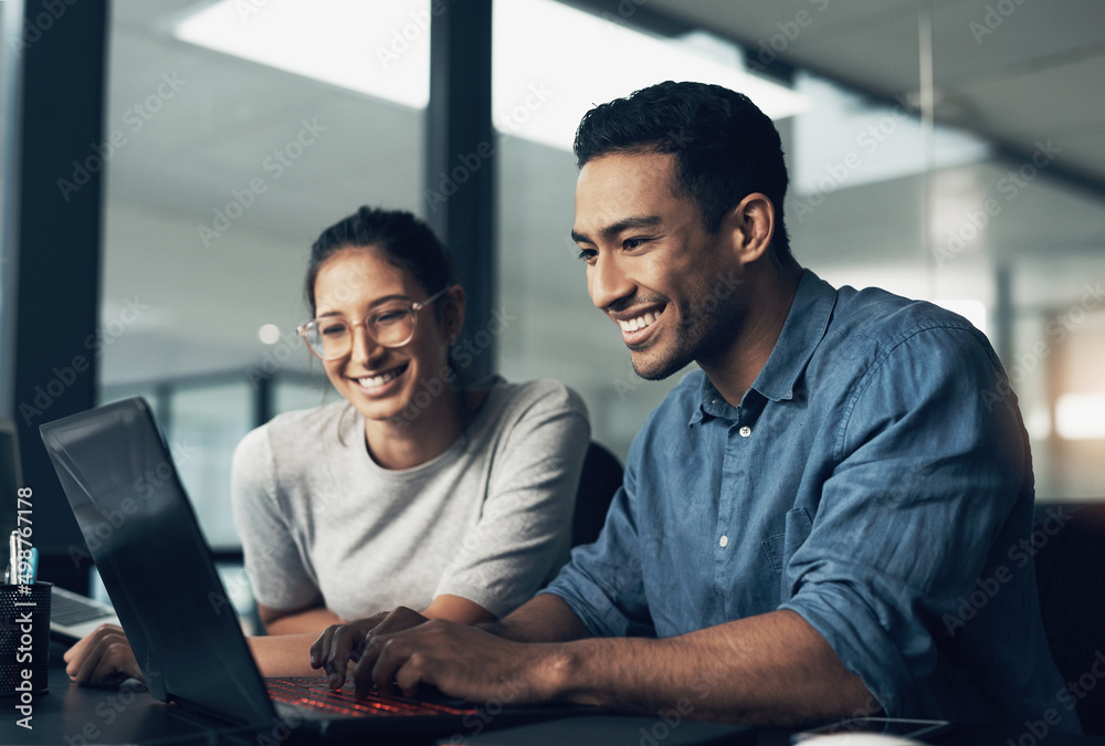 Pick of the litter, never bitter. Shot of two young workers using a laptop in a modern office.