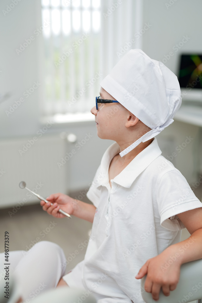 Oral child dental uniform. Mouth healthcare little dentist boy in medical coat.