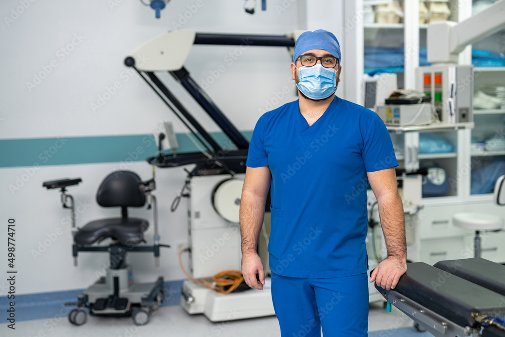 Doctor in uniform and mask posing. Portrait of handsome professional medical worker.