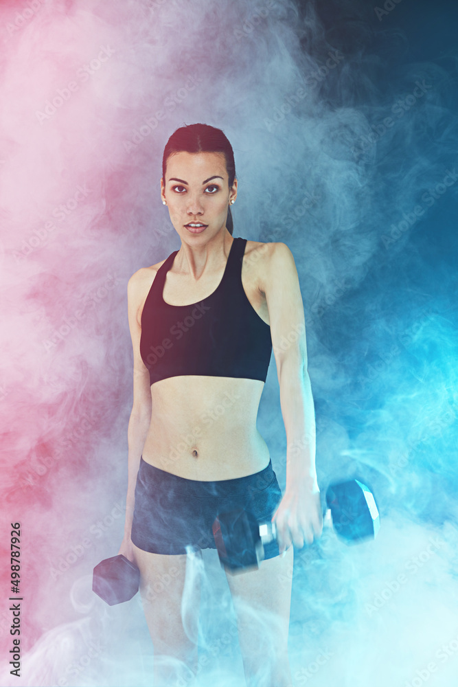 Looking strong, feeling fly. Shot of a young woman working out with dumbbells.