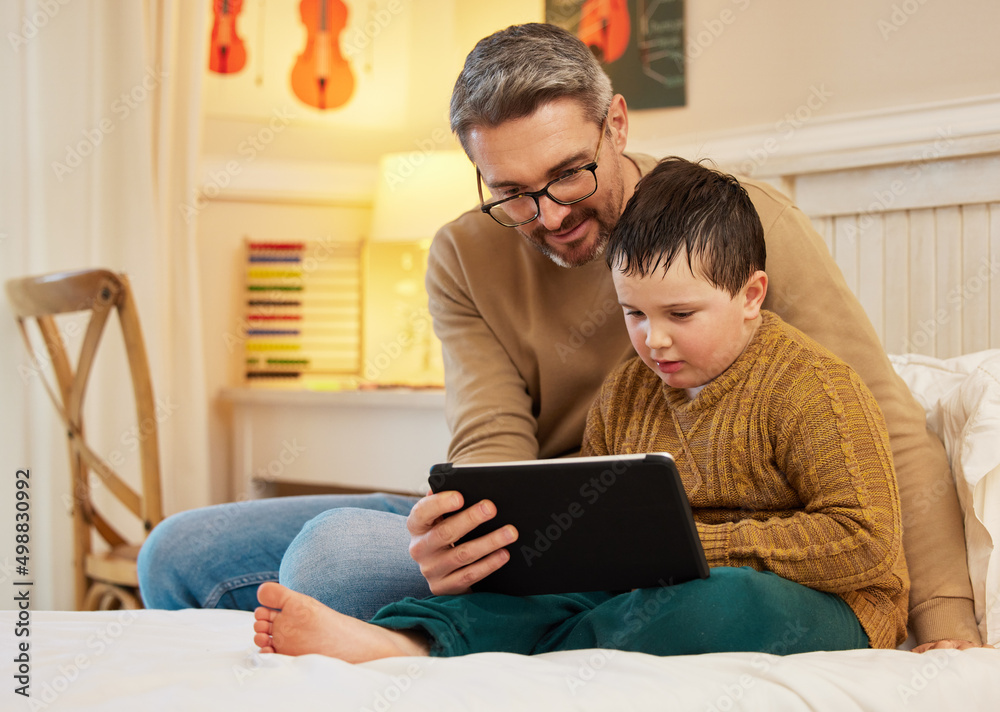 Ill let you watch one last episode before bed. Shot of a father and son using a digital tablet toget