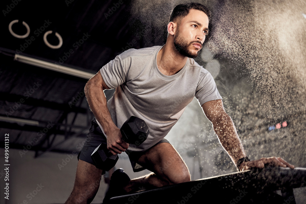 Ive failed over and over, thats why I succeed. Shot of a muscular young man exercising with a dumbbe