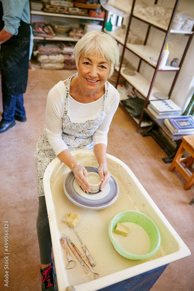 Learning a new skill is so much fun. Shot of a senior woman making a ceramic pot in a workshop.