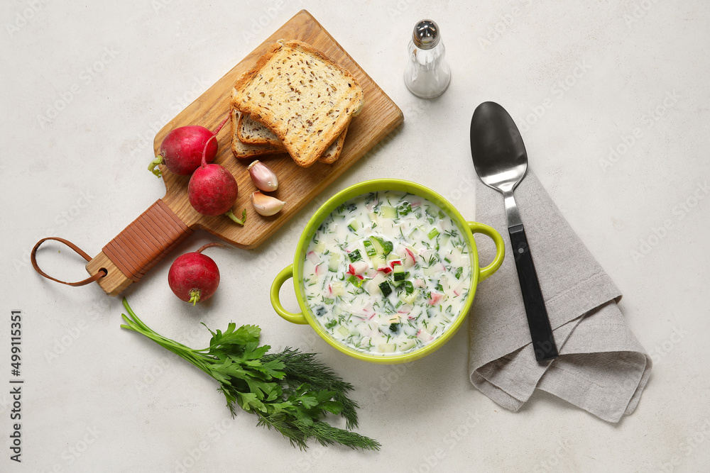 Composition with pot of tasty okroshka and ingredients on light background