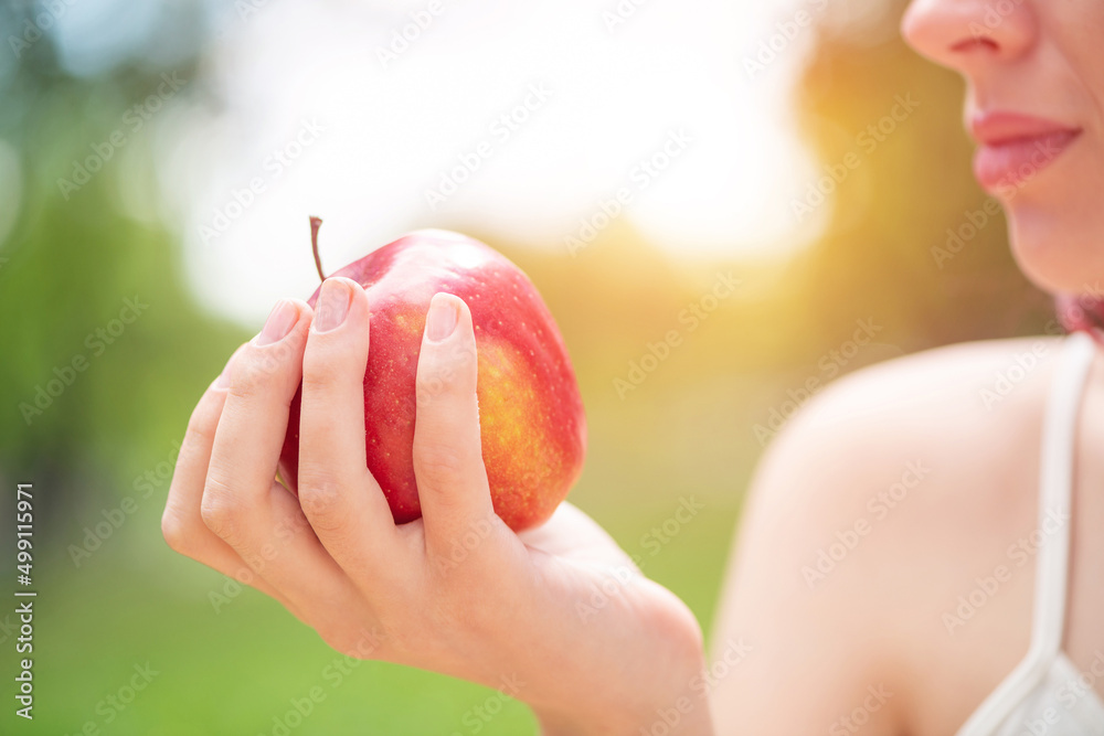 Young woman holds a red apple