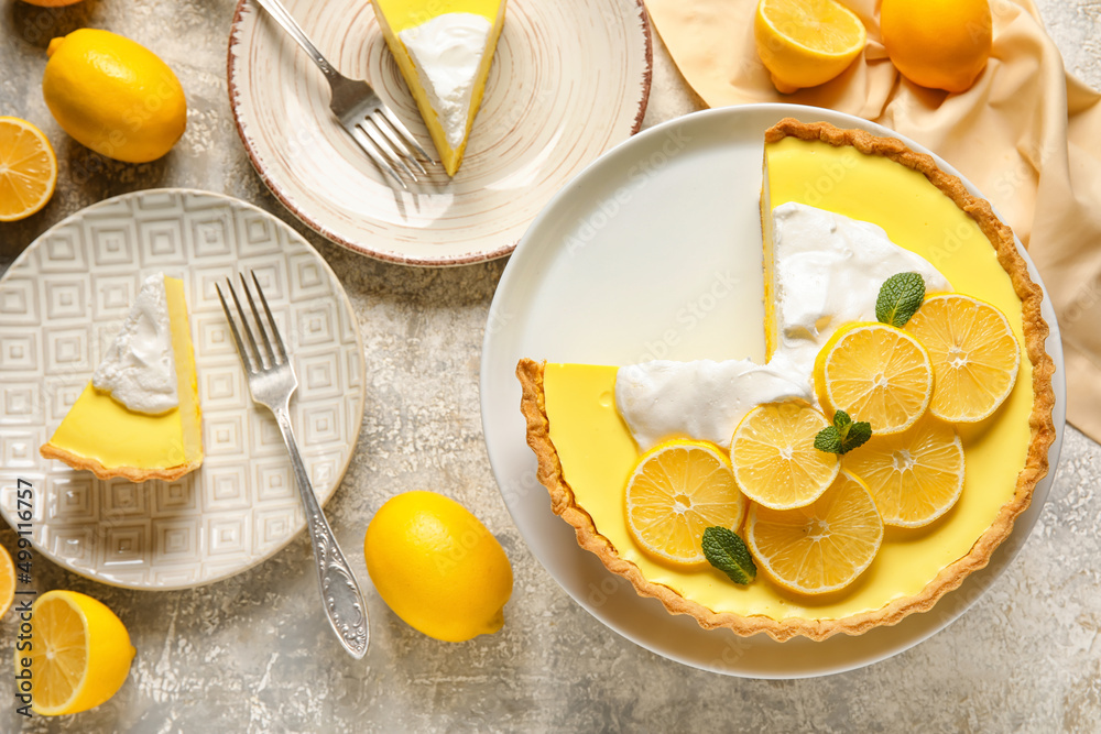 Stand and plates with tasty baked lemon pie on light background