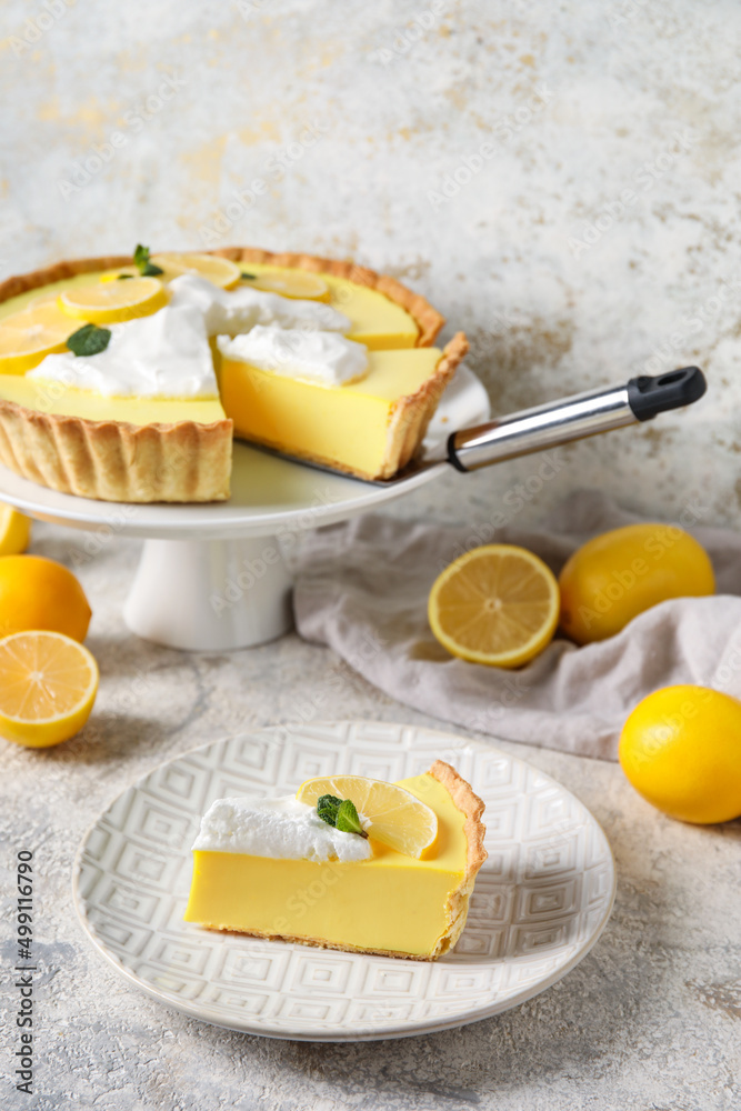 Plate with piece of tasty lemon pie and fresh fruits on light background