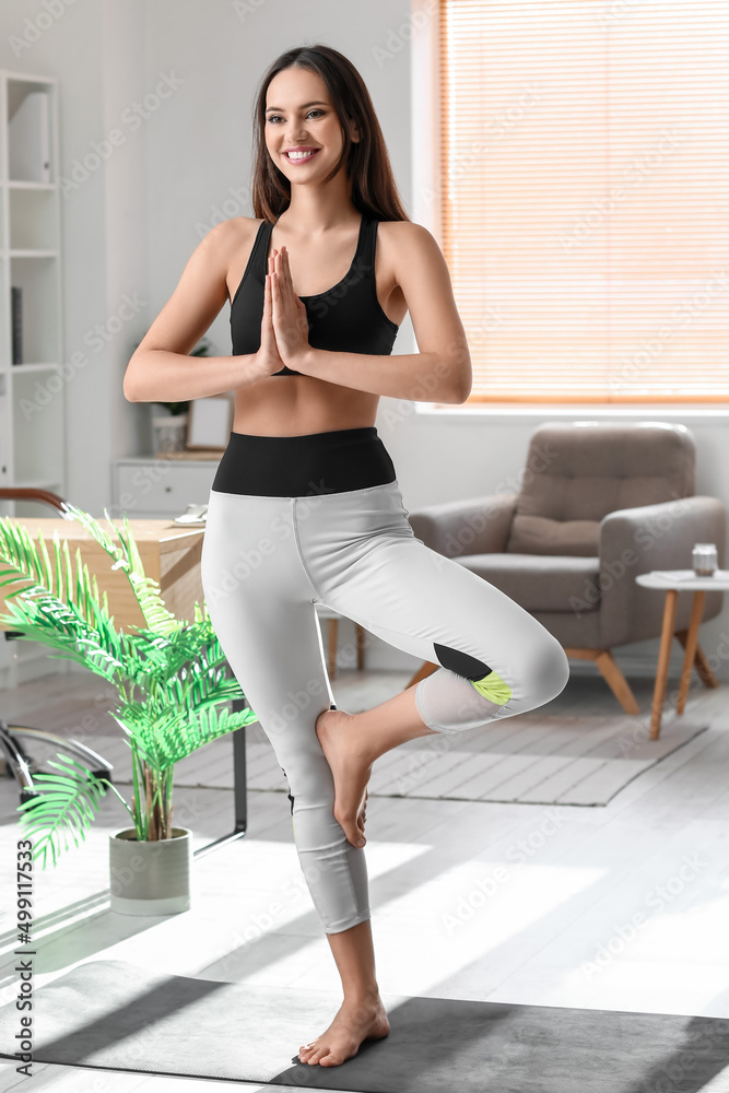 Young barefoot woman meditating at home