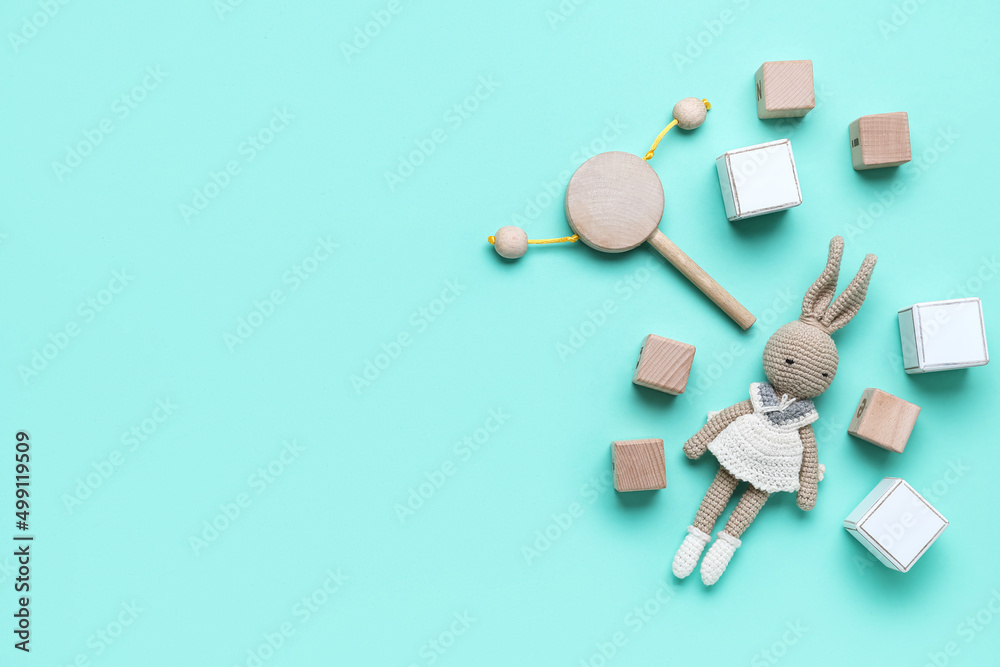 Wooden cubes with baby toys on blue background