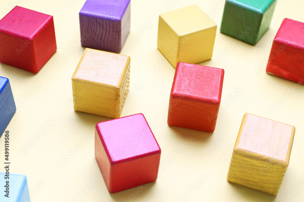 Wooden cubes on yellow background, closeup