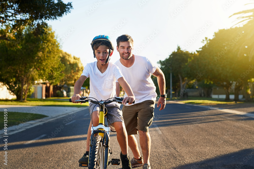 Cycling through his block. Shot of a young boy riding his bicycle through his neighbourhood.