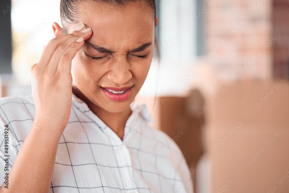 I need a break. Shot of a woman suffering from a headache at home.