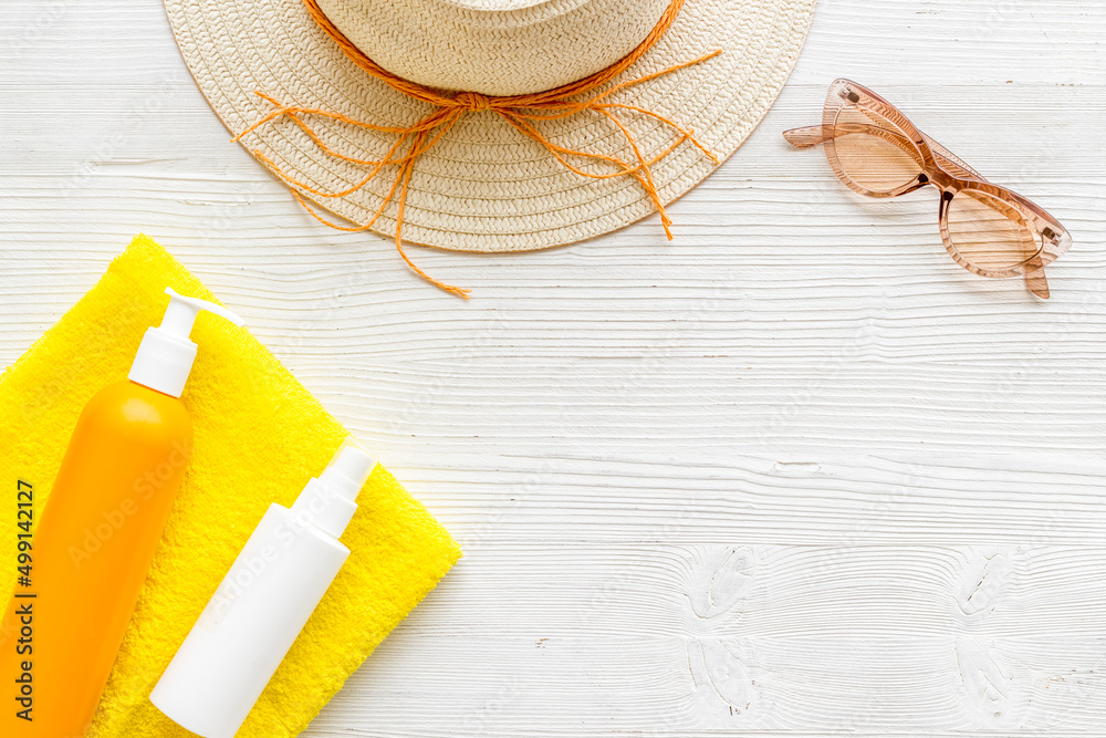 Summertime concept with straw hat and bottles od sunscreen