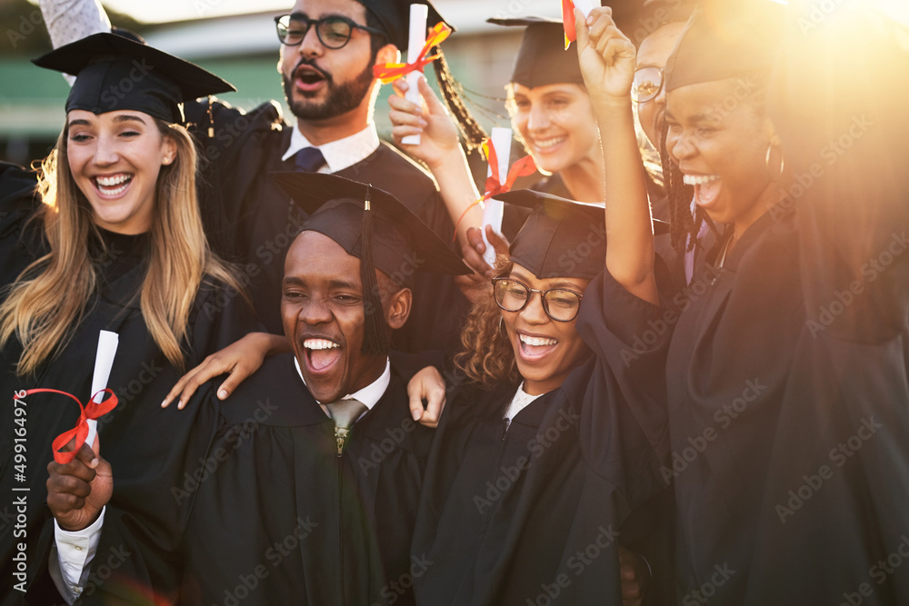 Our parents are so proud of us. Shot of a group of cheerful university students on graduation day.