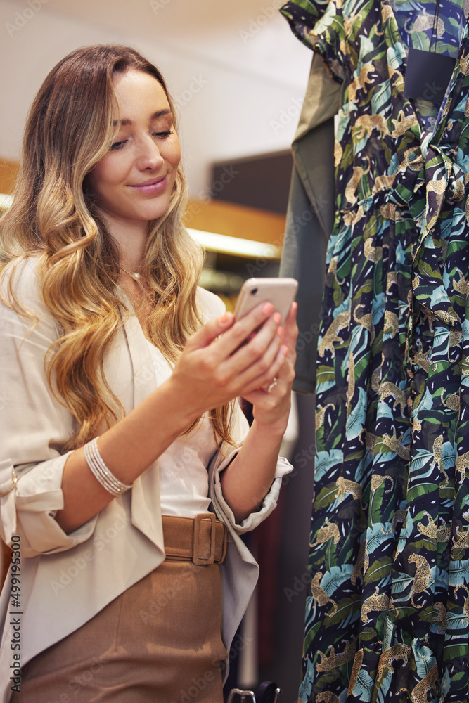 Sweet texts always make me smile. Shot of a young woman using her smartphone while shopping.