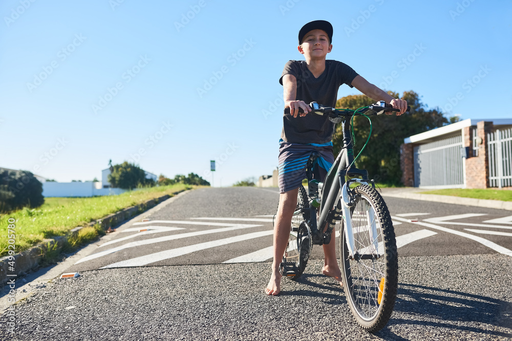 Im cycling the streets. Full length portrait of a young boy riding his bike outside.